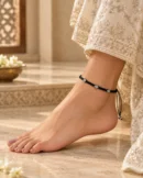 Black flower thread anklet worn naturally with an ivory Indian outfit.