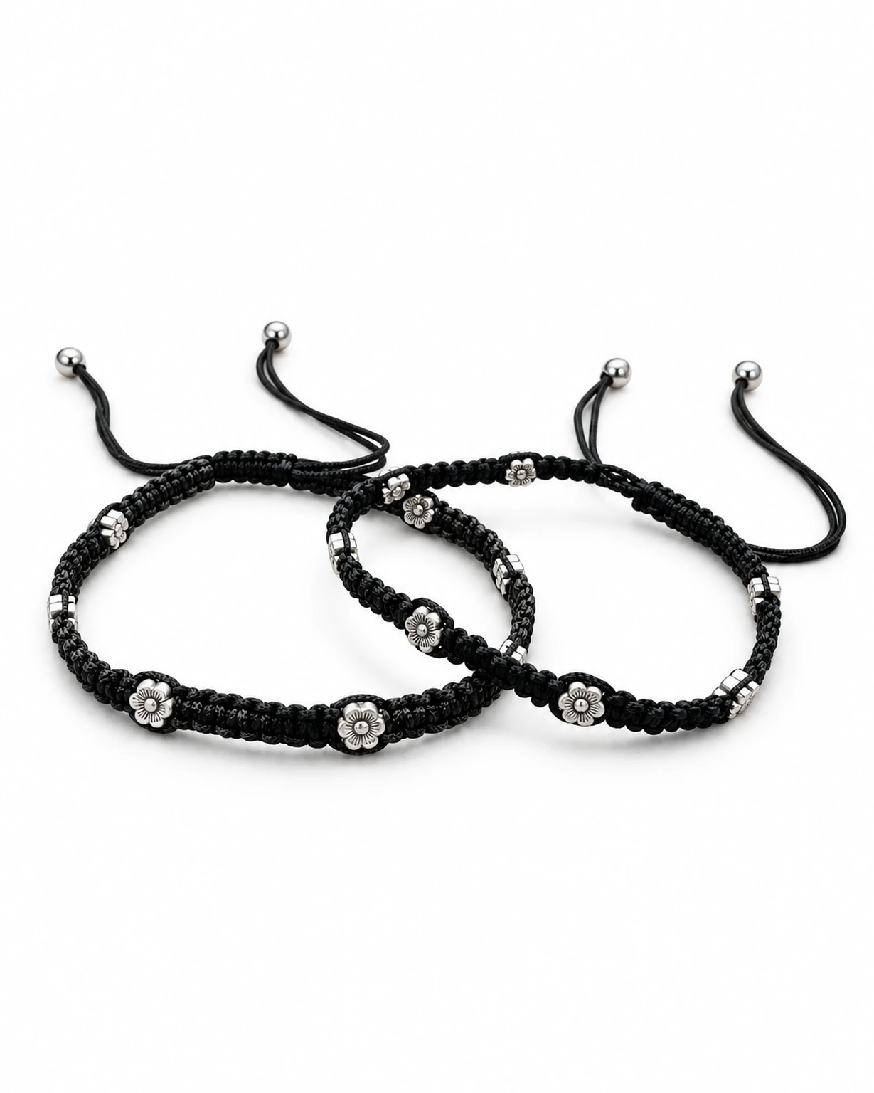 Pair of black flower thread anklets isolated on a plain white e-commerce background.