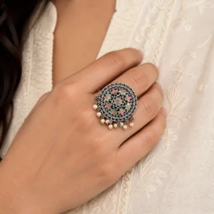 Adjustable pink and green meenakari ring worn naturally with an ivory outfit.