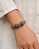 Designer silver kada bracelet worn naturally with an ivory outfit.