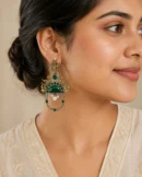 Green two-tone peacock earrings worn naturally with an ivory outfit.