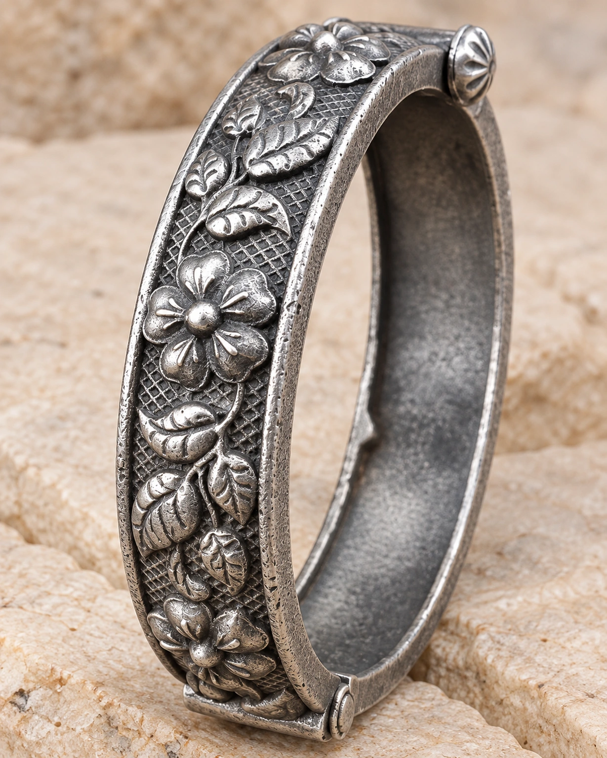 Close-up of raised flowers and leaves on an oxidised kada bracelet