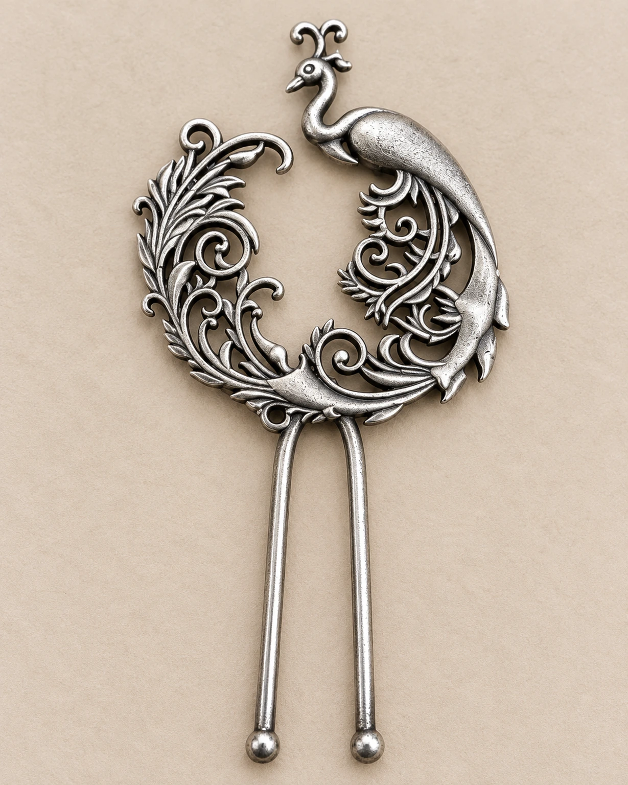 Close-up of the peacock motif and pierced floral scrollwork on an oxidised juda pin.