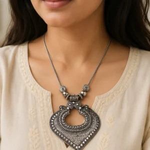 Oxidized silver necklace worn naturally with an ivory outfit.