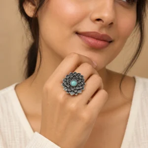 Turquoise oxidized vintage flower ring worn naturally with an ivory outfit.