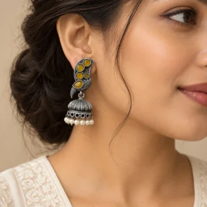 Mustard stone silver designer bird earrings worn naturally with an ivory outfit.